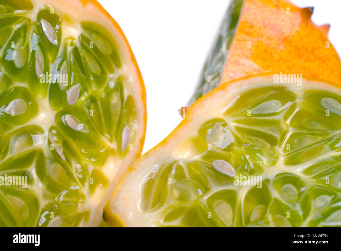 A juicy sliced open horned or Kiwano melon showing the seeds and yellow