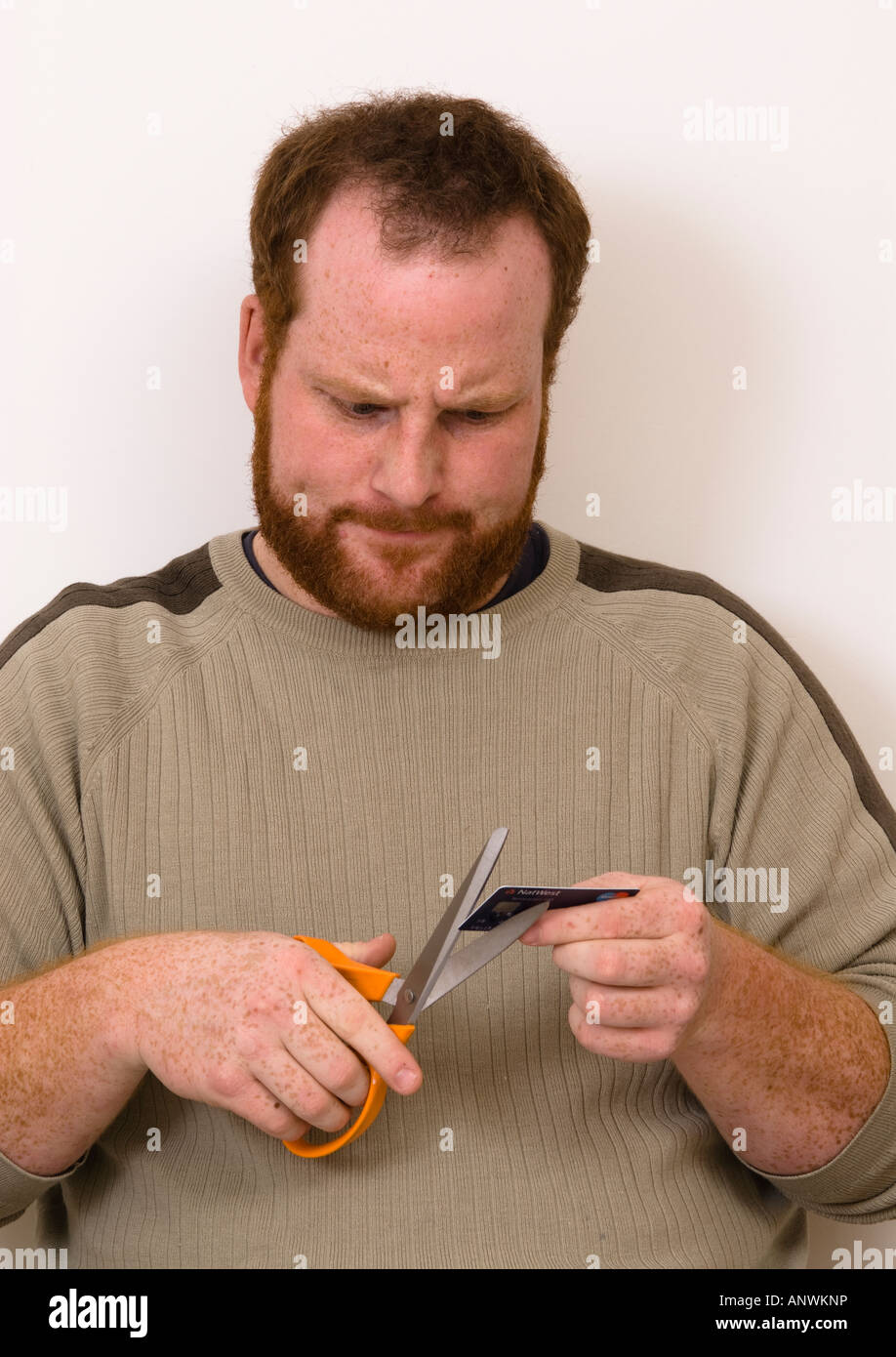 angry man cutting up destroying credit debit bank card Stock Photo