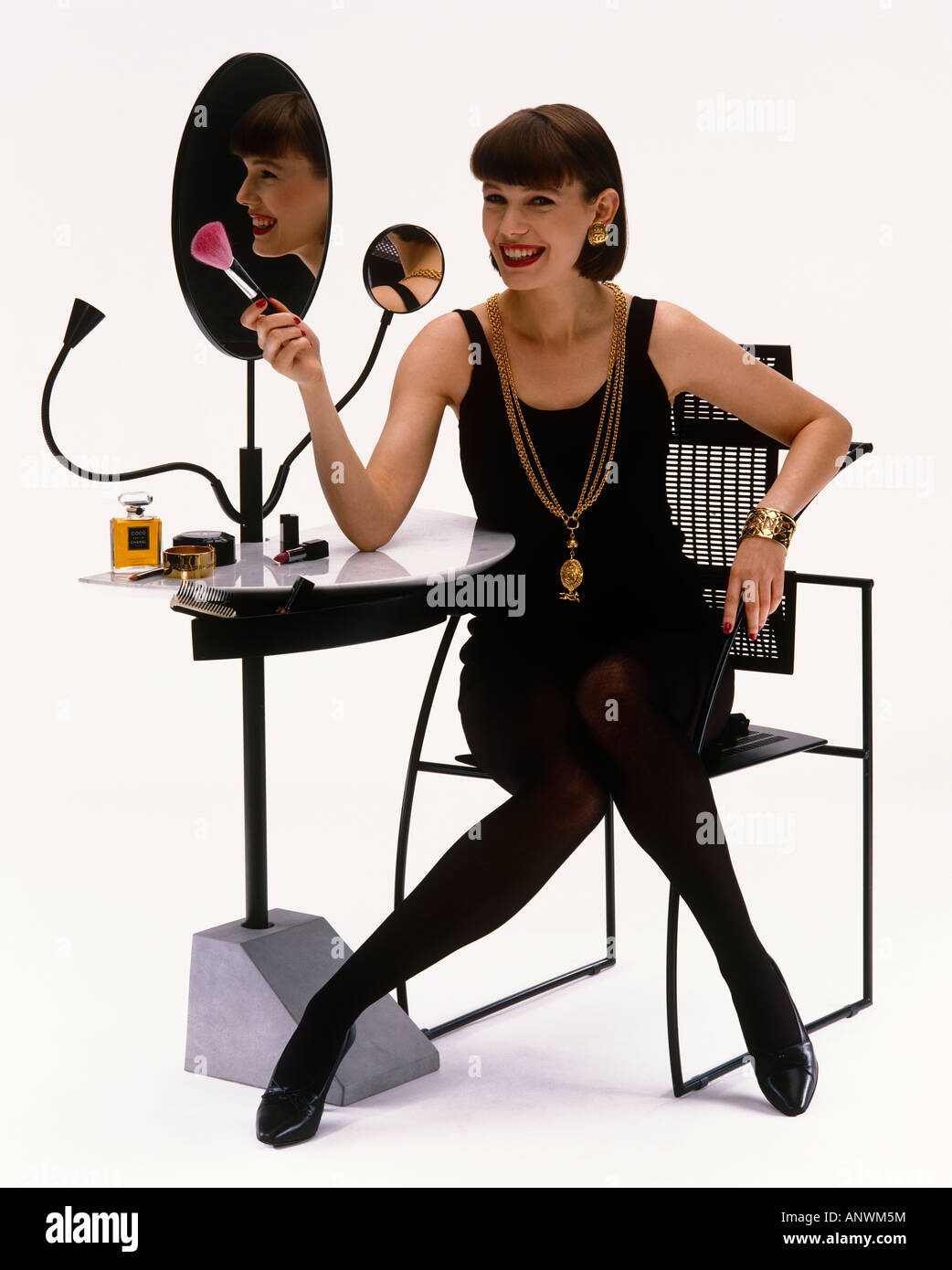 Woman at Dressing Table applying make-up with reflection Stock Photo