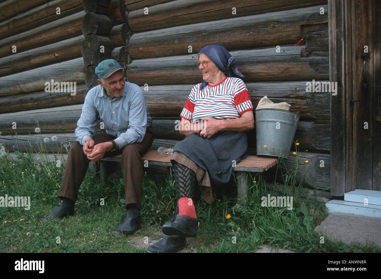 old farmer couple conversing at the end of the day, sitting on a bench, Lithuania, Aukstaitija Stock Photo