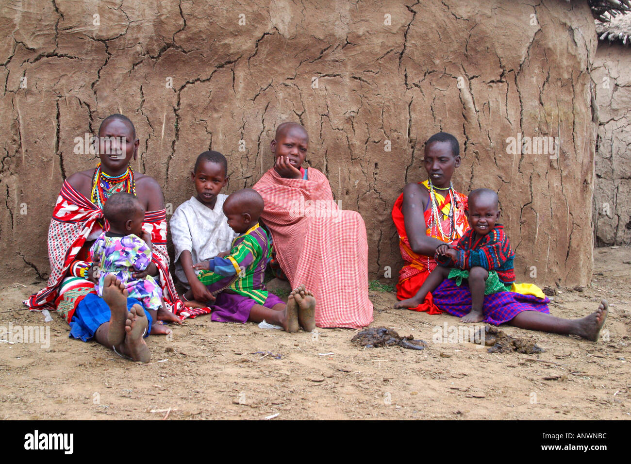 Maasai women babies young children mud huts sticks cow dung  Masai Mara Stock Photo