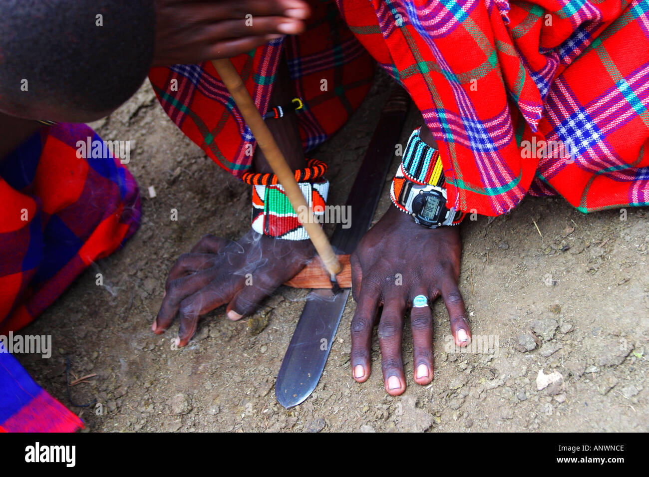 Maasai warriors making fire Masai Mara National Nature Reserve Kenya East Africa Stock Photo