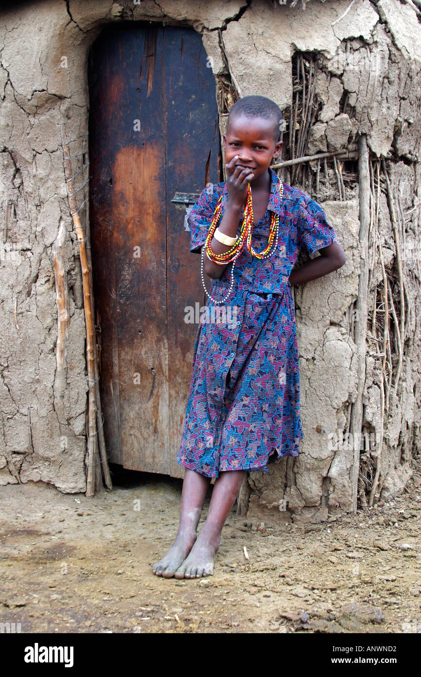 Maasai girl outside village mud hut made of sticks and cow dung Masai Mara National Nature Reserve Kenya Stock Photo