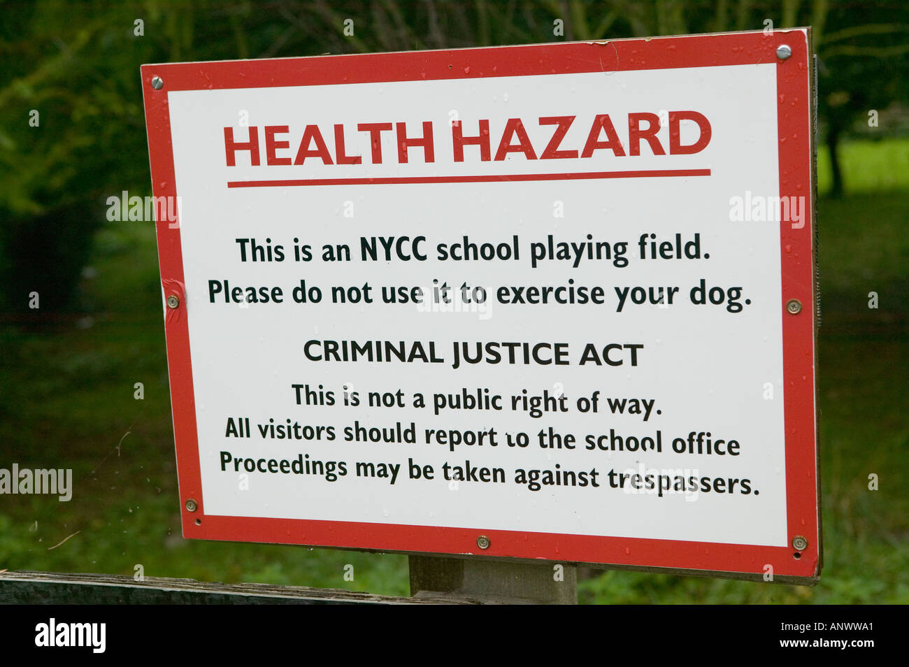 Health hazard sign about dog excrement on school playing field Settle Yorkshire England Stock Photo