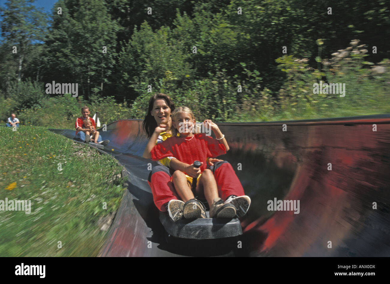 mother with child on an all-weather toboggan chute, Austria, Windischgarsten Stock Photo
