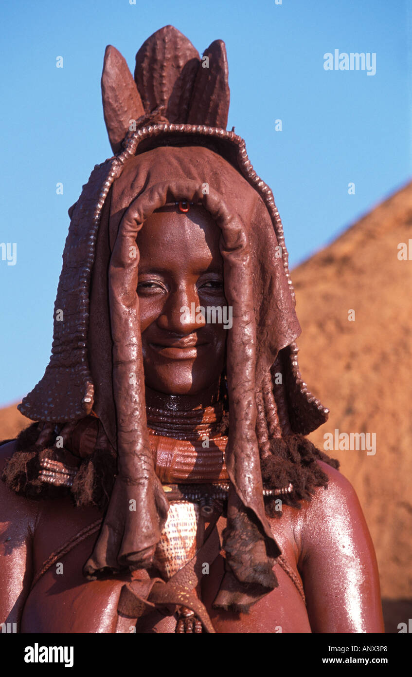 A Himba woman, with red clay spread on her body, wearing a traditional head dress, in Namibia, Africa (MR) Stock Photo