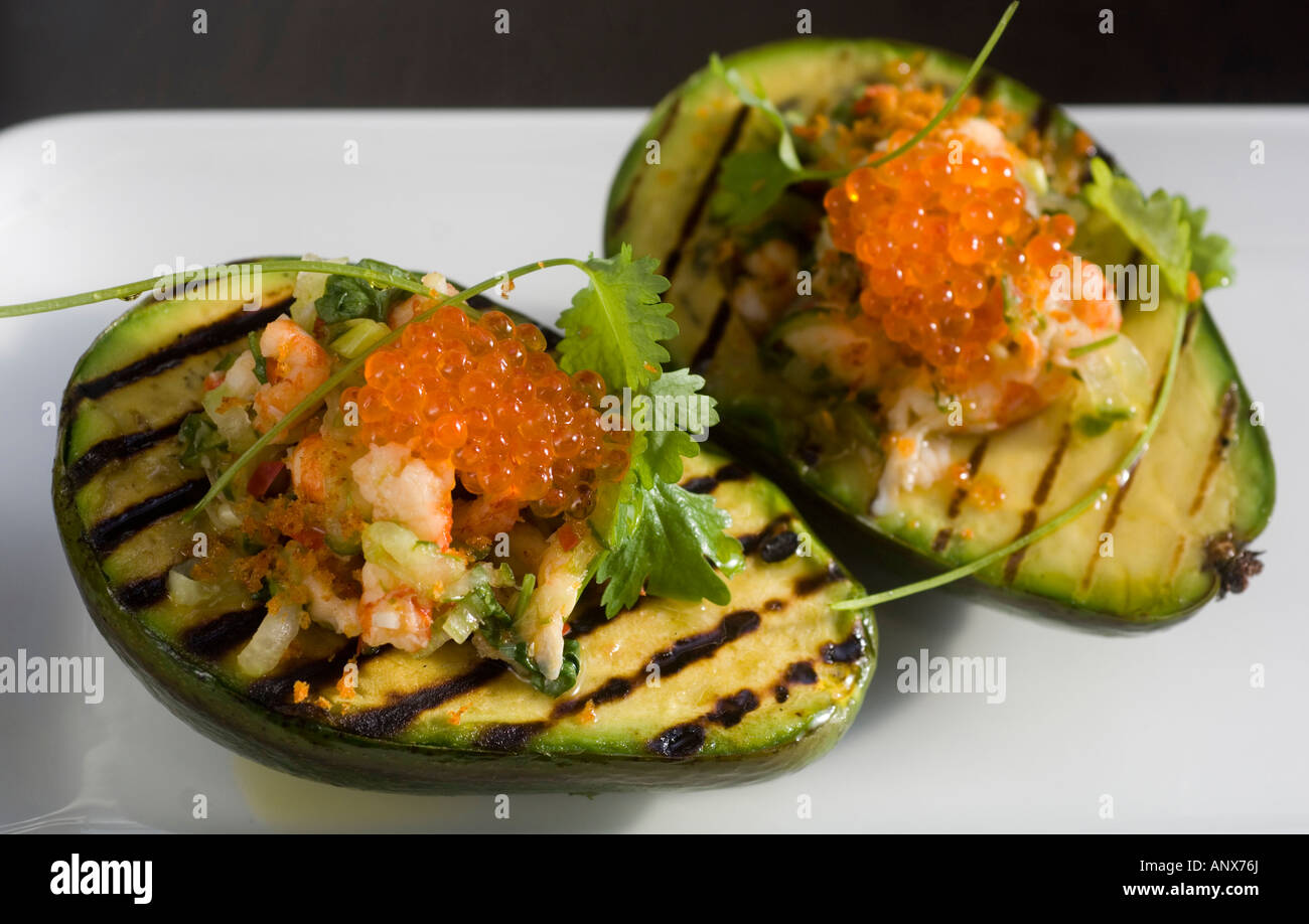 Grilled avocado filled with shrimps and bleak roe Stock Photo