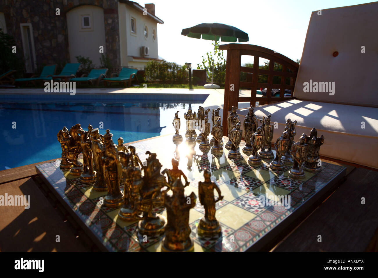 Exotic chess set next to swimming pool at villa in Turkey Stock Photo