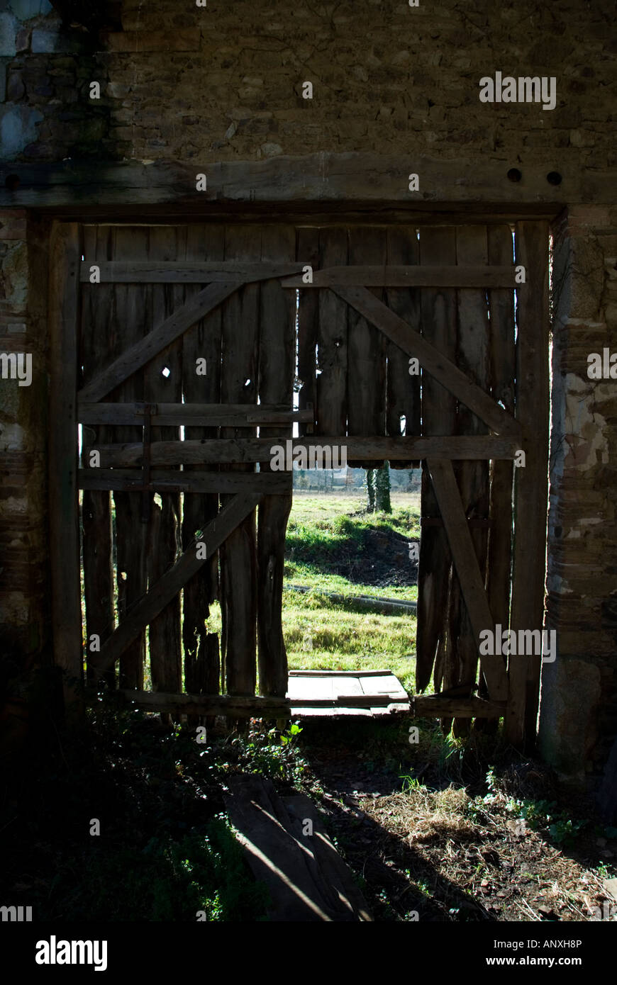 an old broken barn door with shafts of light entering the barn through