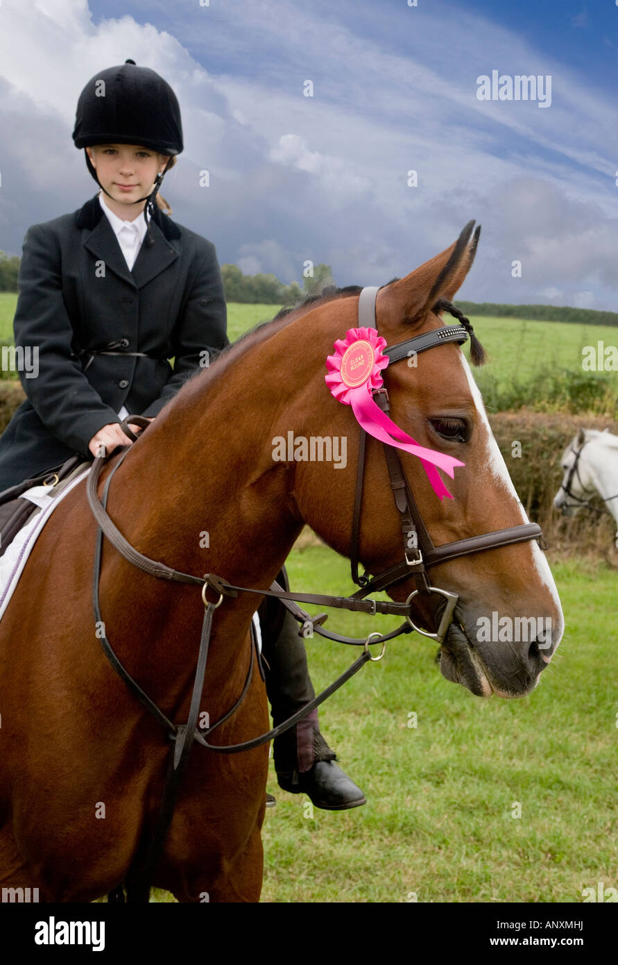 YOUNG GIRL IN RIDING OUTFIT WITH PONY AND AWARD ROSETTE Stock Photo