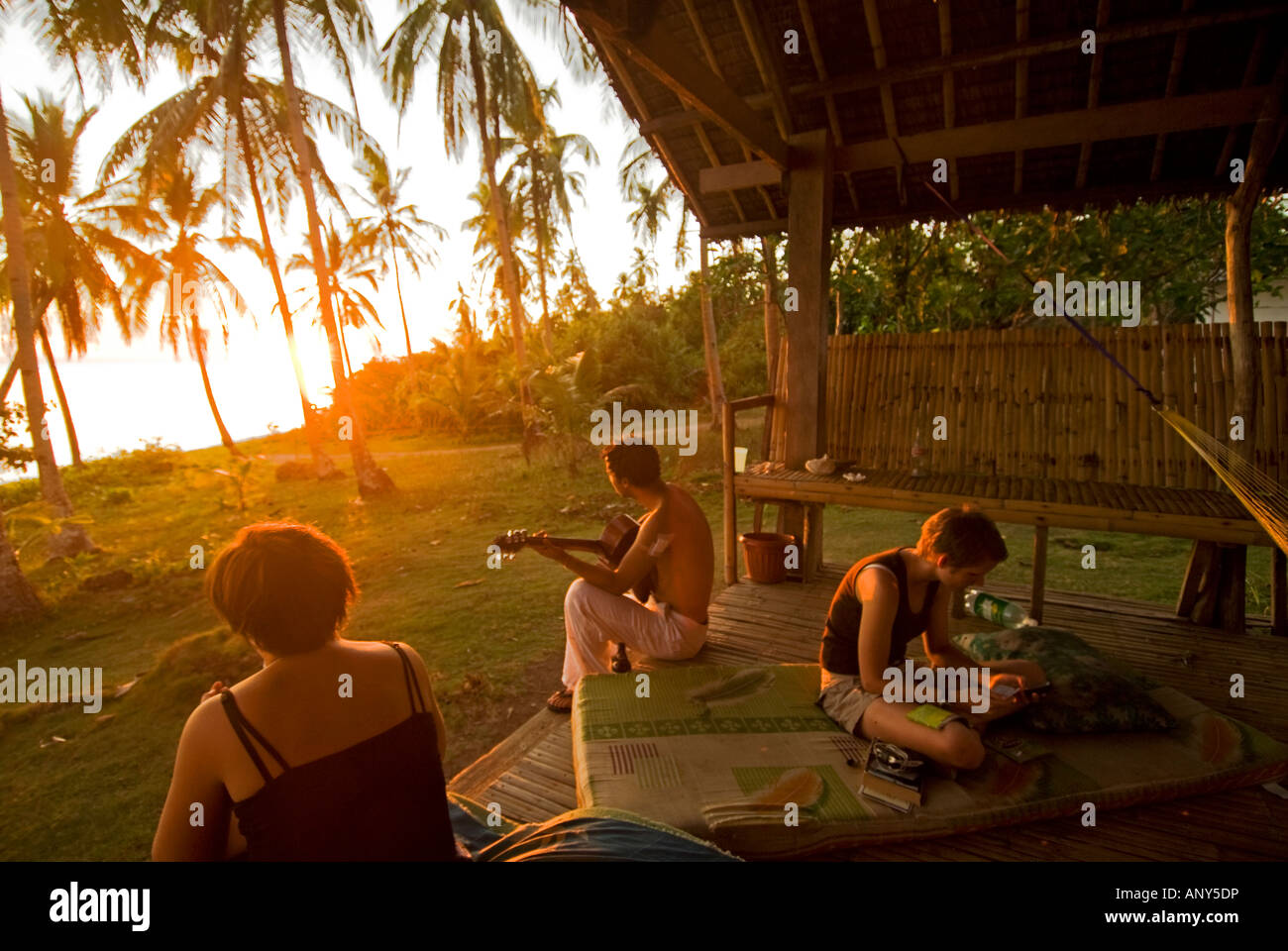 Philippines, Southern Leyte. Coral Cay Conservation volunteers relaxing at sunset after dive surveys. Stock Photo
