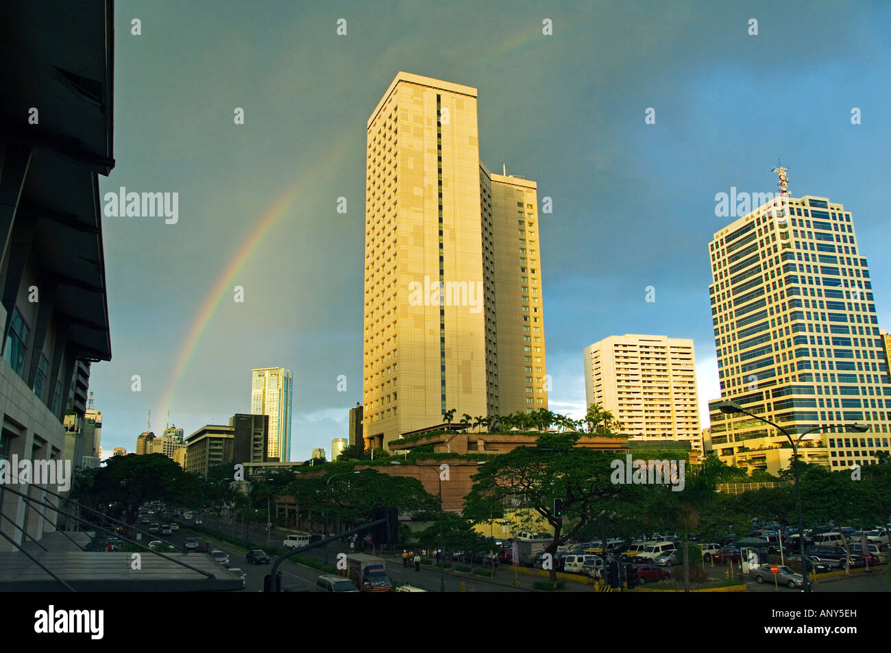 Philippines, Luzon, Manila. Makati business district with Louis Vuitton  advertising board and a rainbow over the city skyline Stock Photo - Alamy