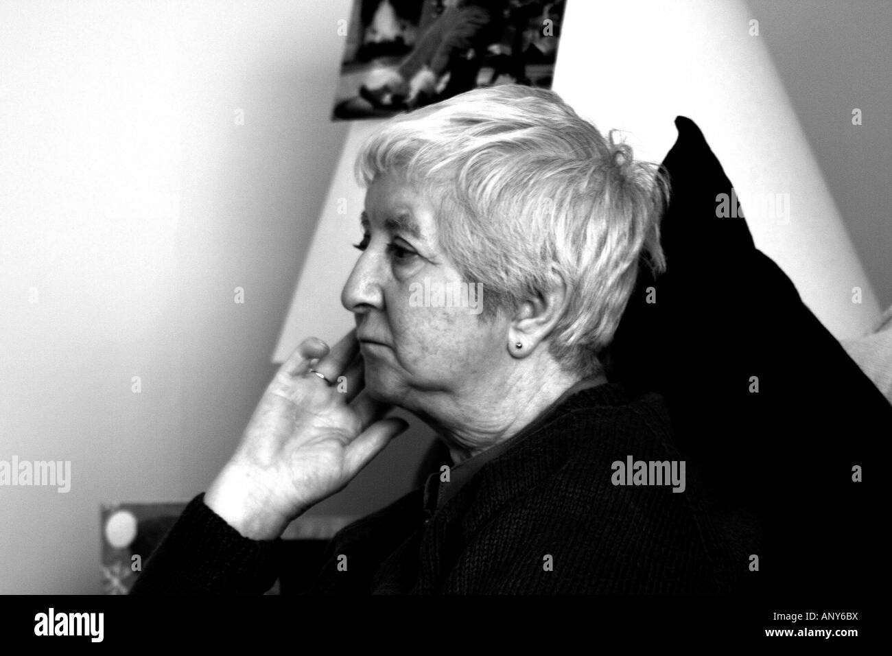 Elderly lady sitting looking reflective, contemplative Stock Photo