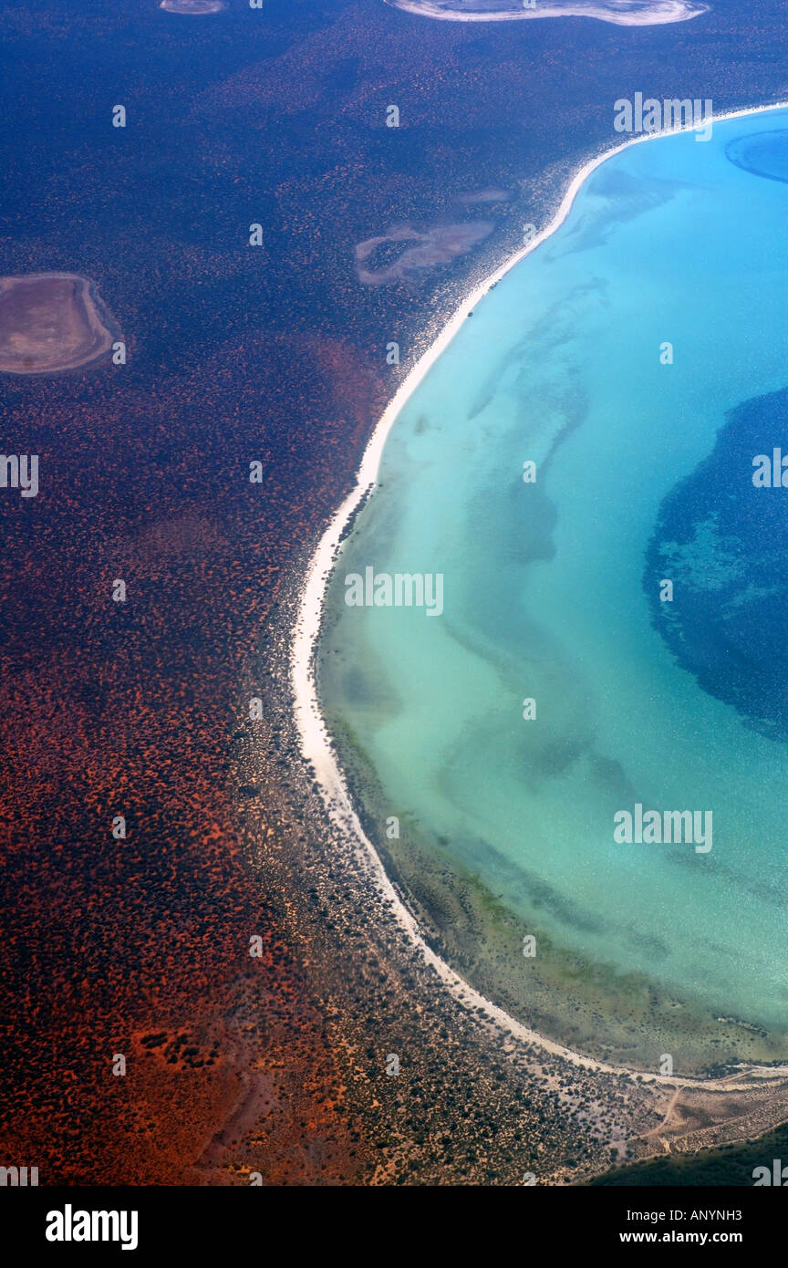 Shark Bay Marine Park and World Heritage Area aerial view of section of coastline showing seagrass beds and arid red landscape Stock Photo