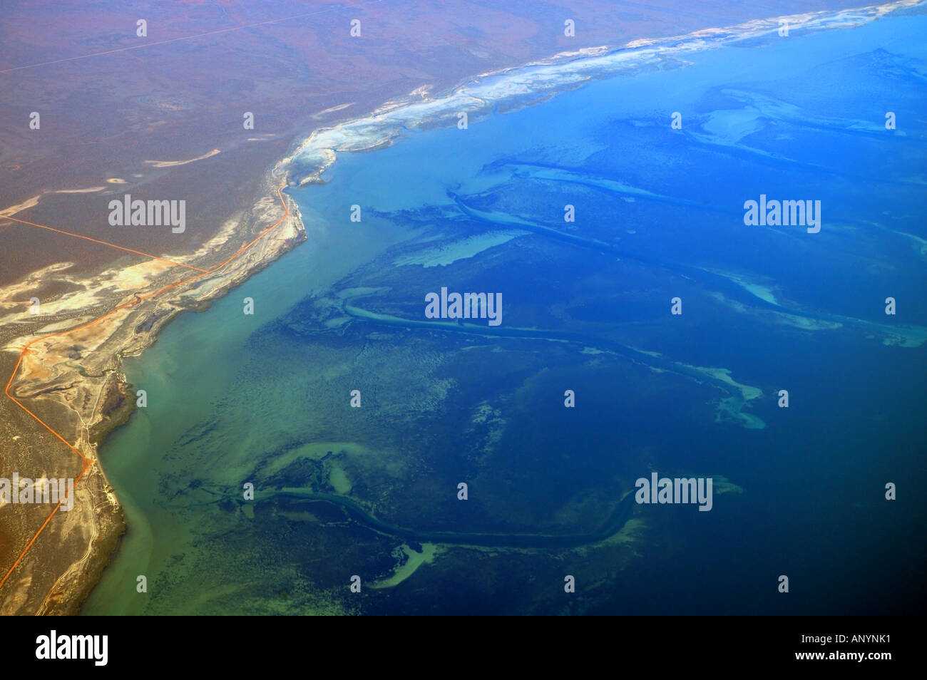 Shark Bay Marine Park and World Heritage Area aerial view showing channels through seagrass beds and arid red landscape Stock Photo
