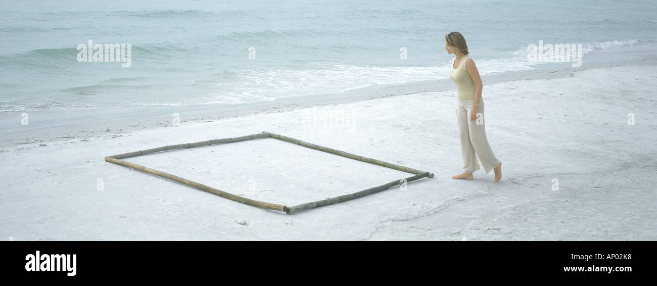 Woman approaching square shape on beach Stock Photo