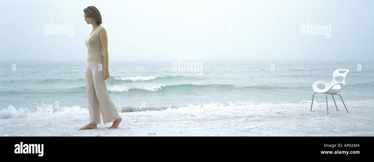 Woman Walking Away From Chair On Beach Stock Photo Alamy