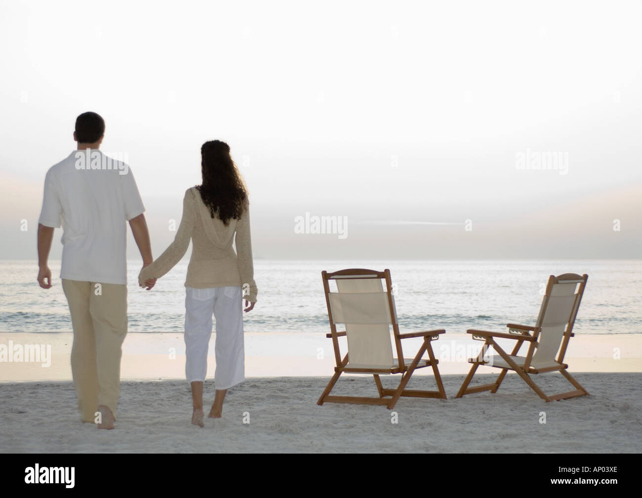 Two Couples In Love On Chairs On The Beach Stock Photos Two
