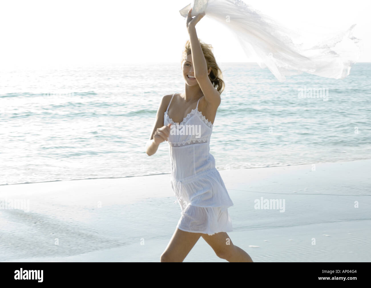Woman On Beach Holding Up Piece Of Clothing In Wind Stock Photo Alamy