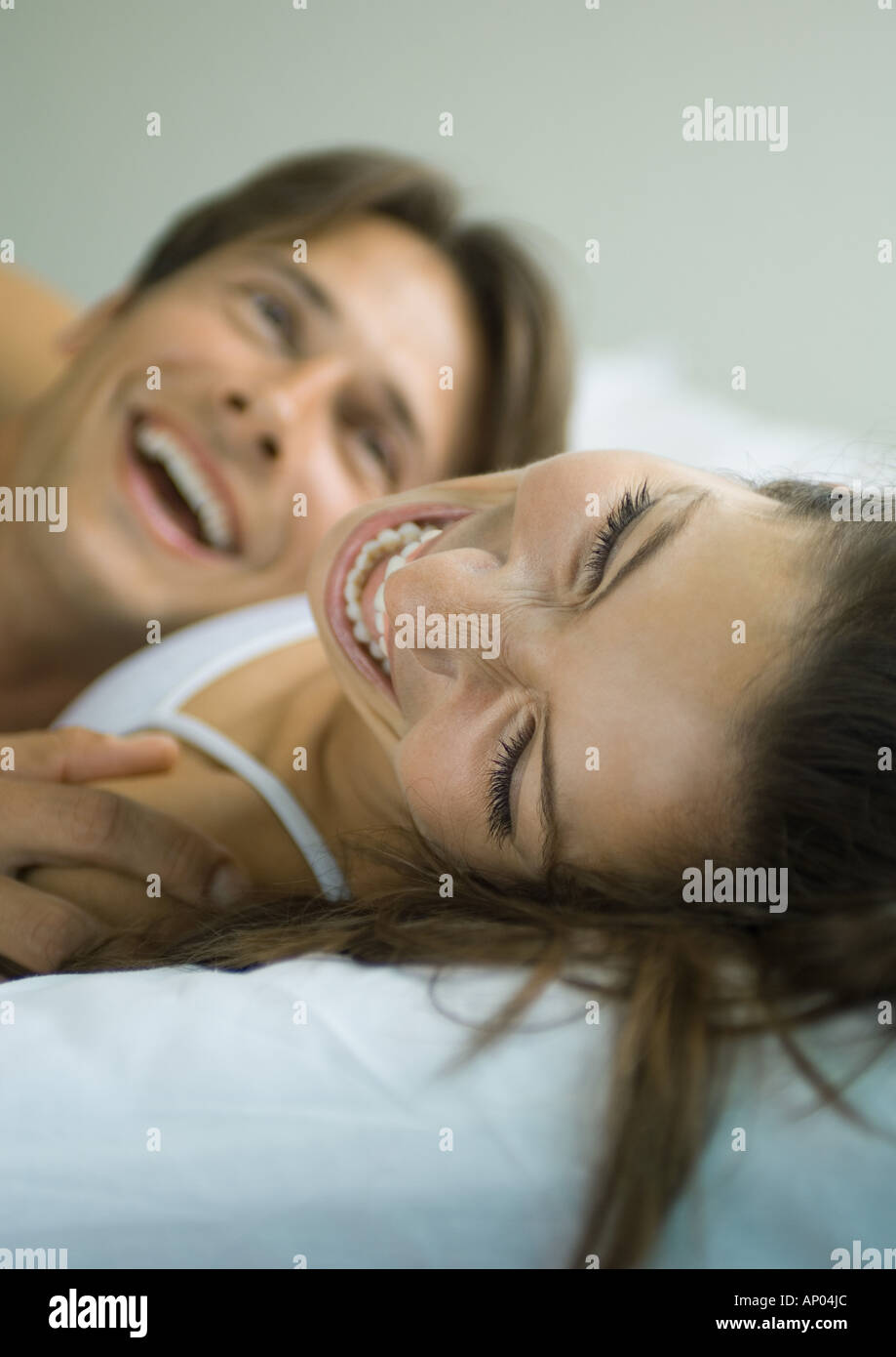 Couple lying in bed, laughing Stock Photo