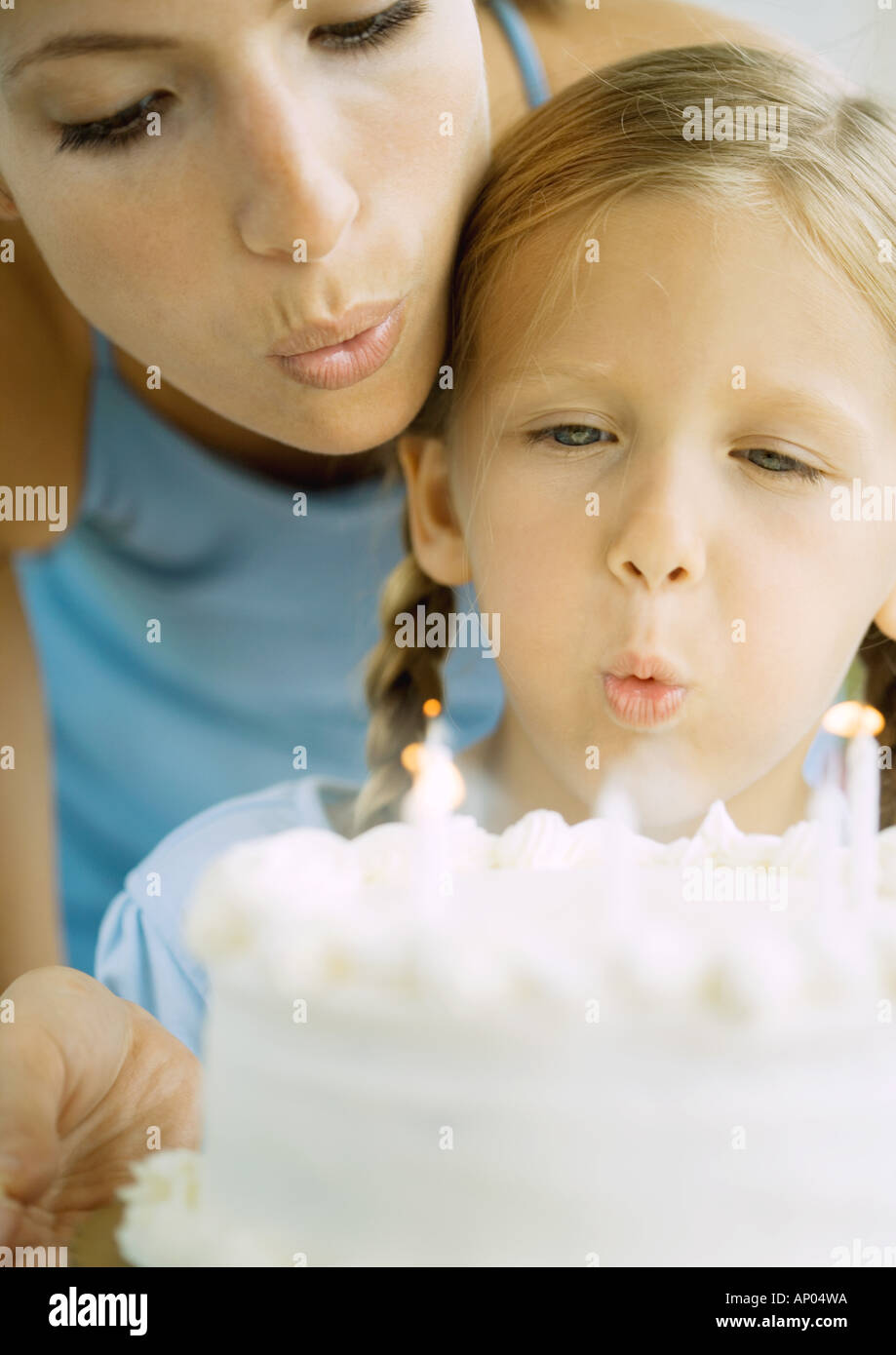 Mother and girl blowing out candles on birthday cake Stock Photo Alamy