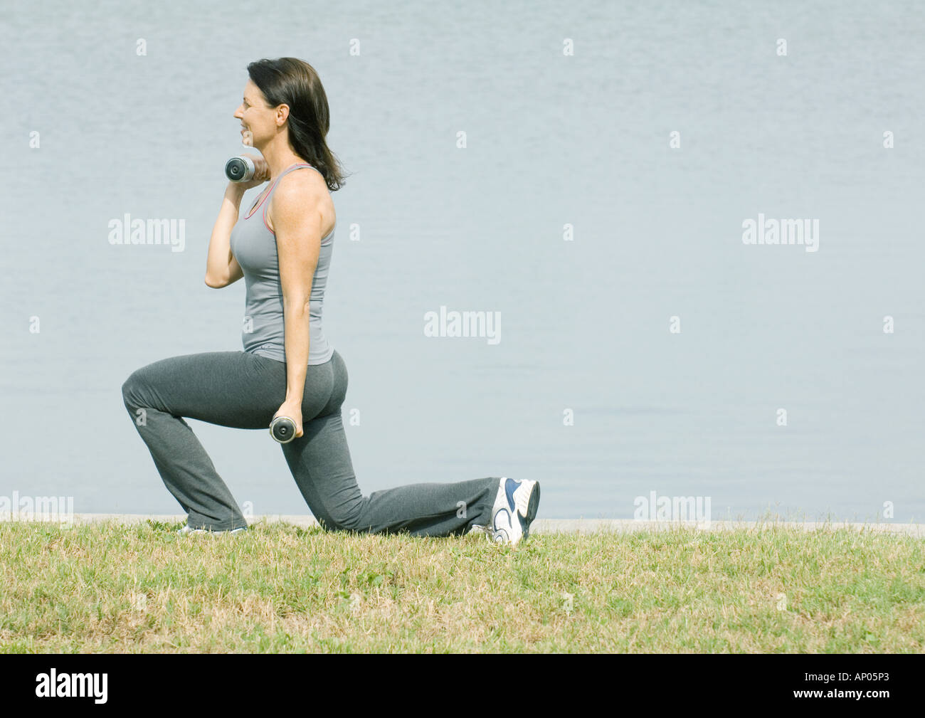 Woman working out by edge of water Stock Photo