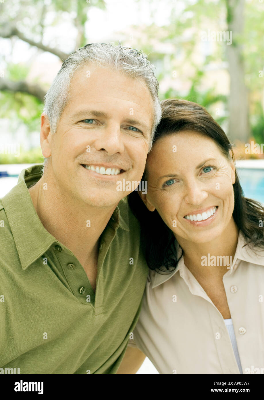 Mature couple smiling, portrait, pool in background Stock Photo