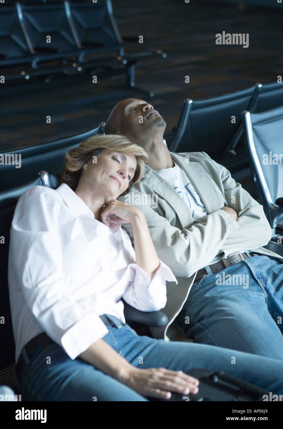 Travelers sleeping in airport lounge Stock Photo Alamy