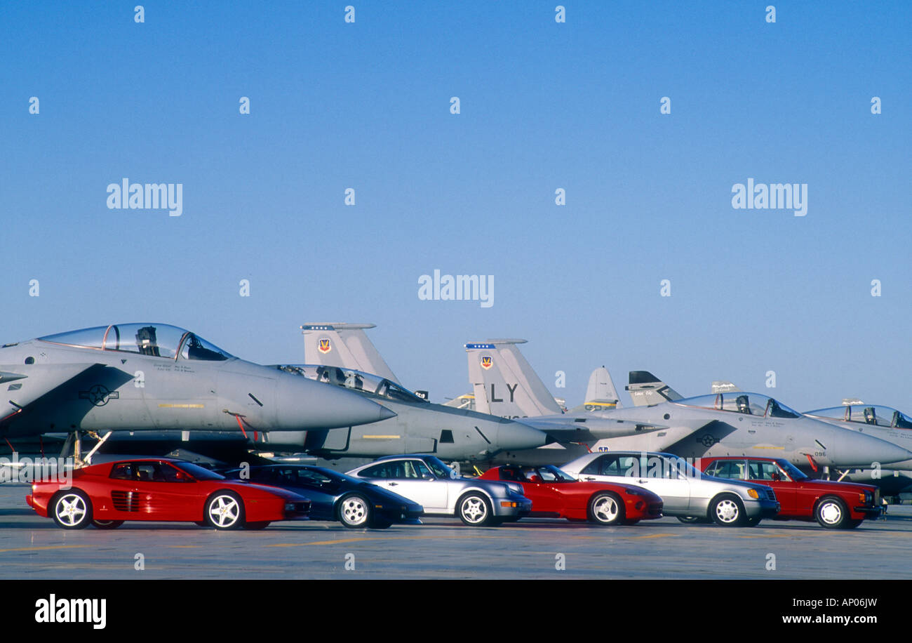Group of 1980's luxury cars parked with F16 fighter jets. Stock Photo