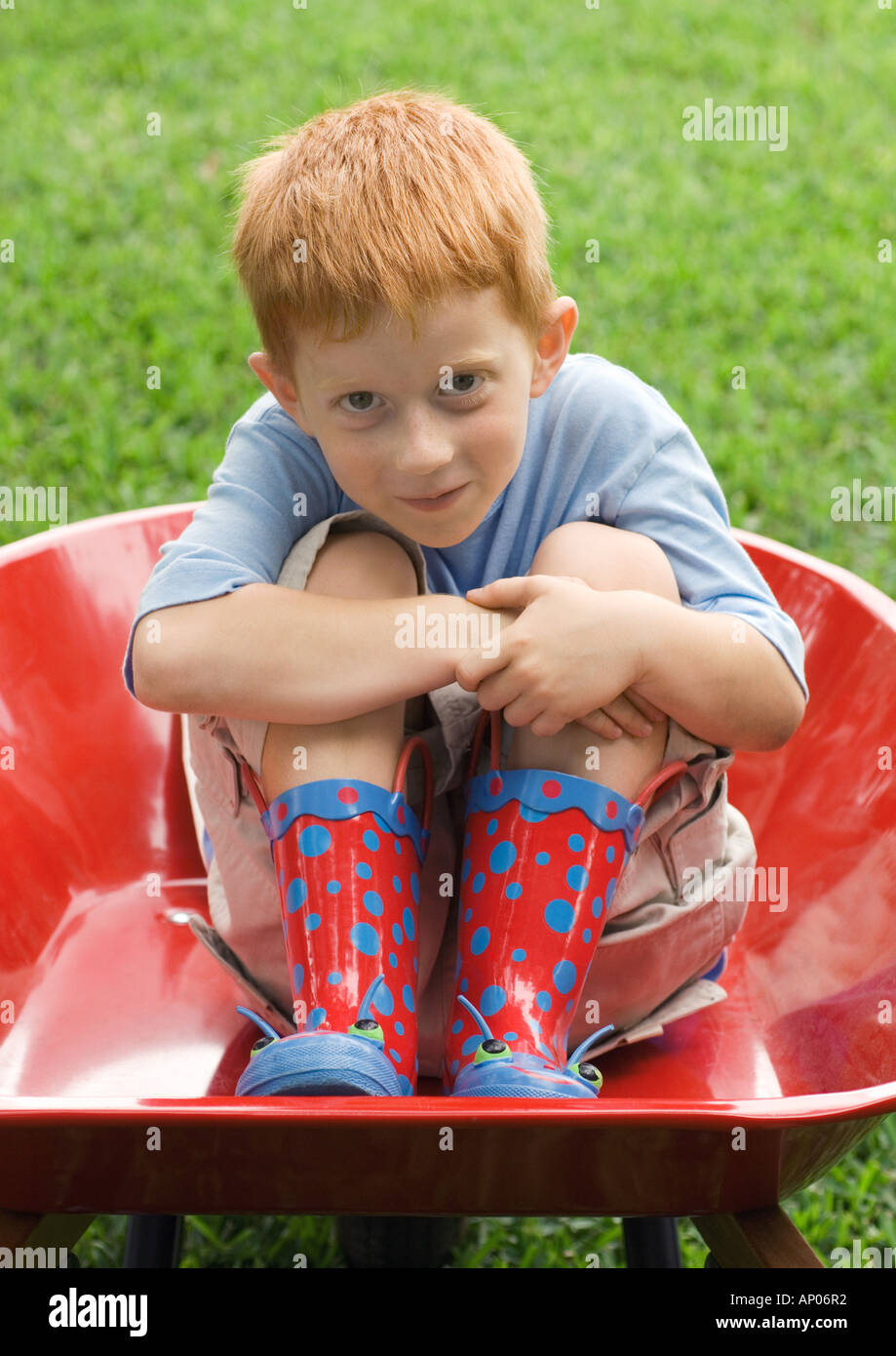 Little boy sitting in wheelbarrow Stock Photo - Alamy