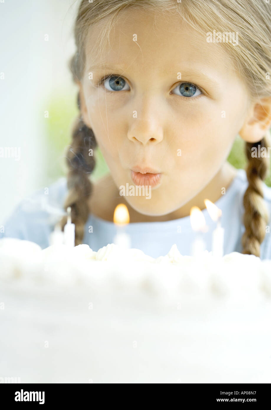 Little girl blowing out candles on birthday cake Stock Photo Alamy