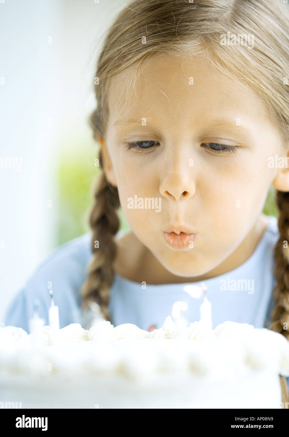 Little girl blowing out candles on birthday cake Stock Photo Alamy