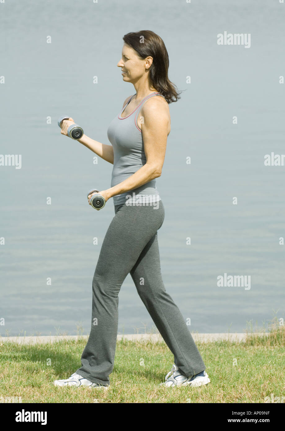 Woman lifting weights near edge of water Stock Photo Alamy