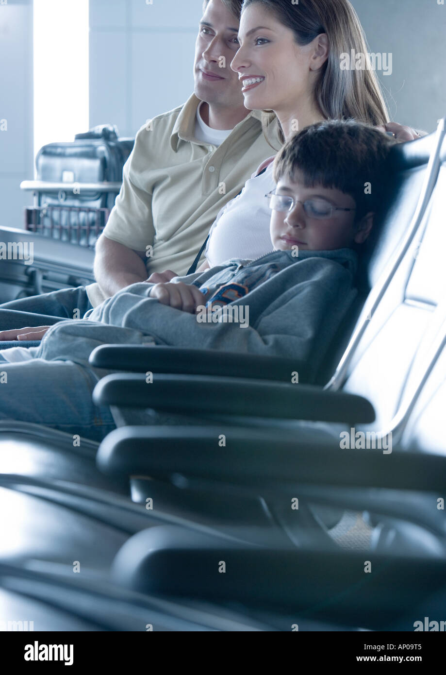 Family sitting in airport lounge, boy sleeping Stock Photo Alamy