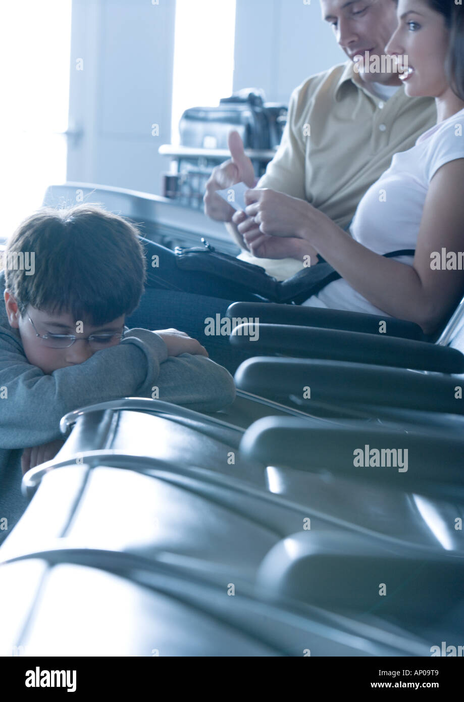 Family sitting in airport lounge, boy sleeping Stock Photo Alamy