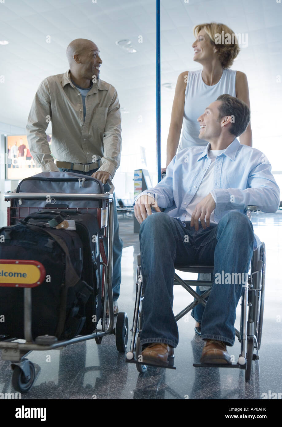 Travelers in airport, one in wheelchair Stock Photo Alamy