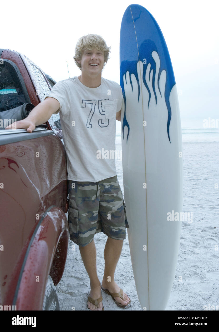 Surfer standing next to pickup truck with surfboard Stock Photo Alamy