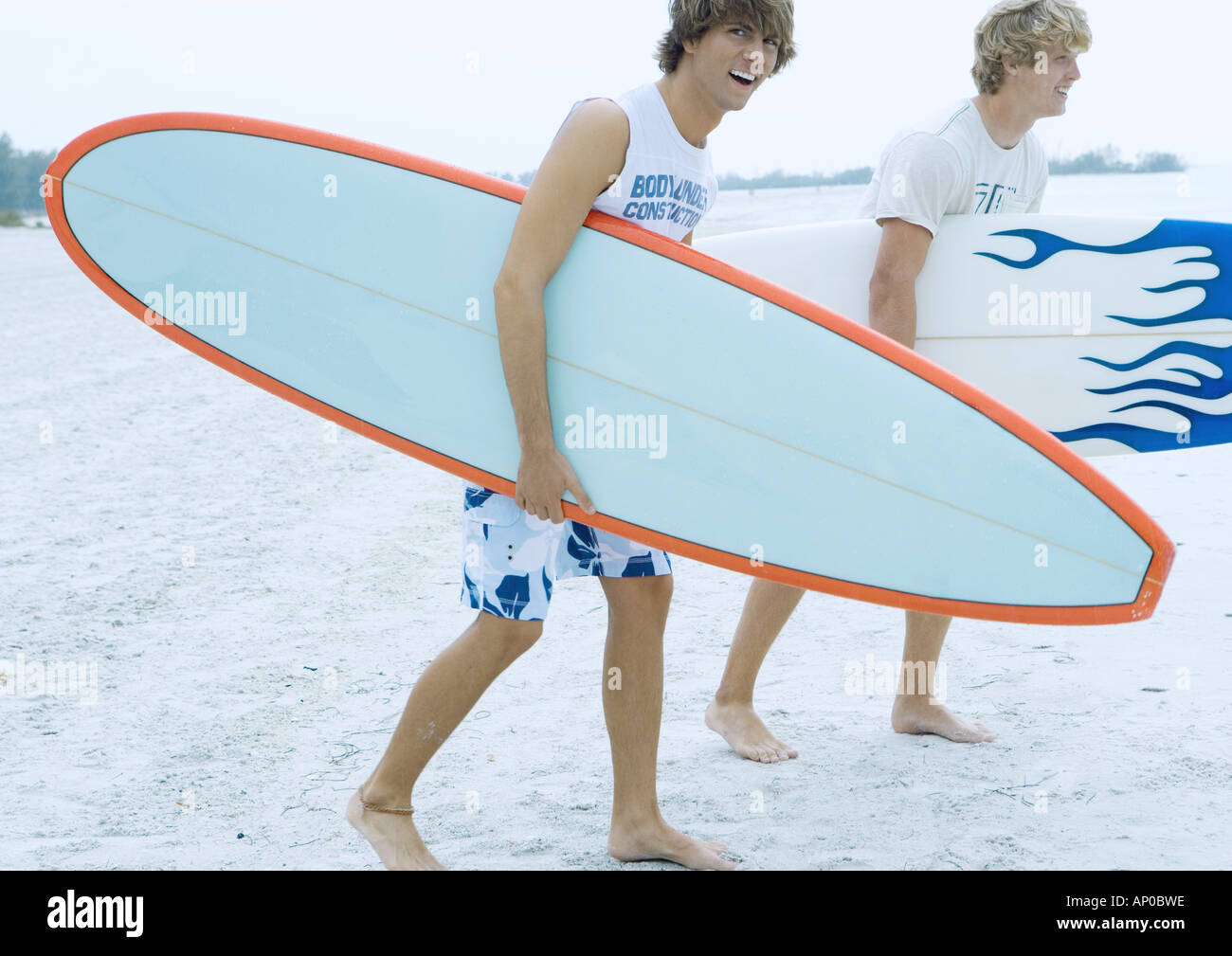 Surfers carrying surfboards Stock Photo Alamy