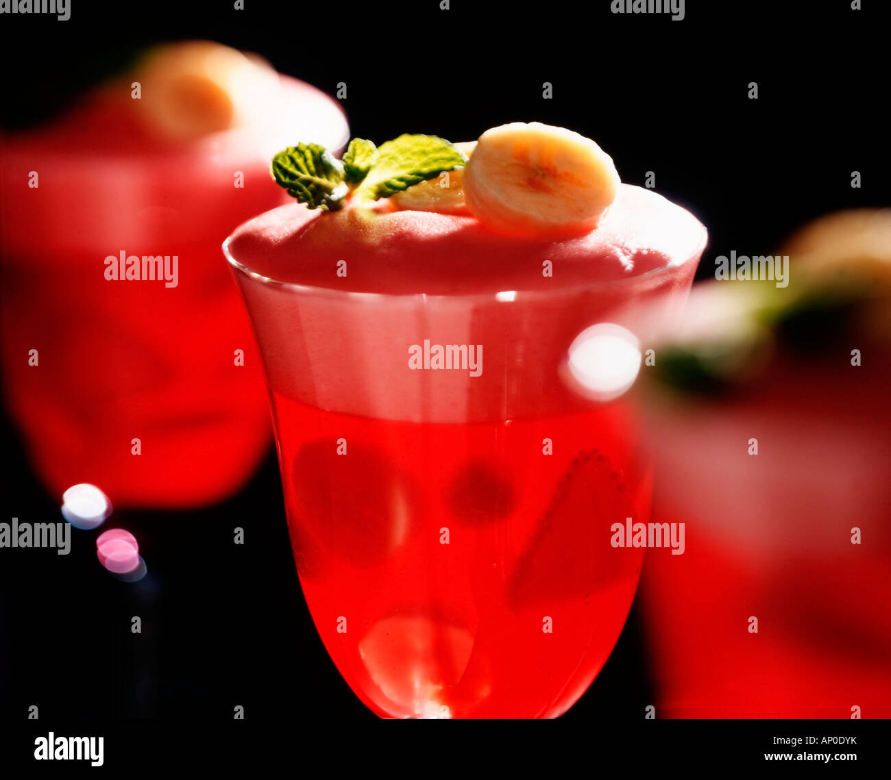 Red Gelatin dessert with bananas and mint garnish Stock Photo Alamy