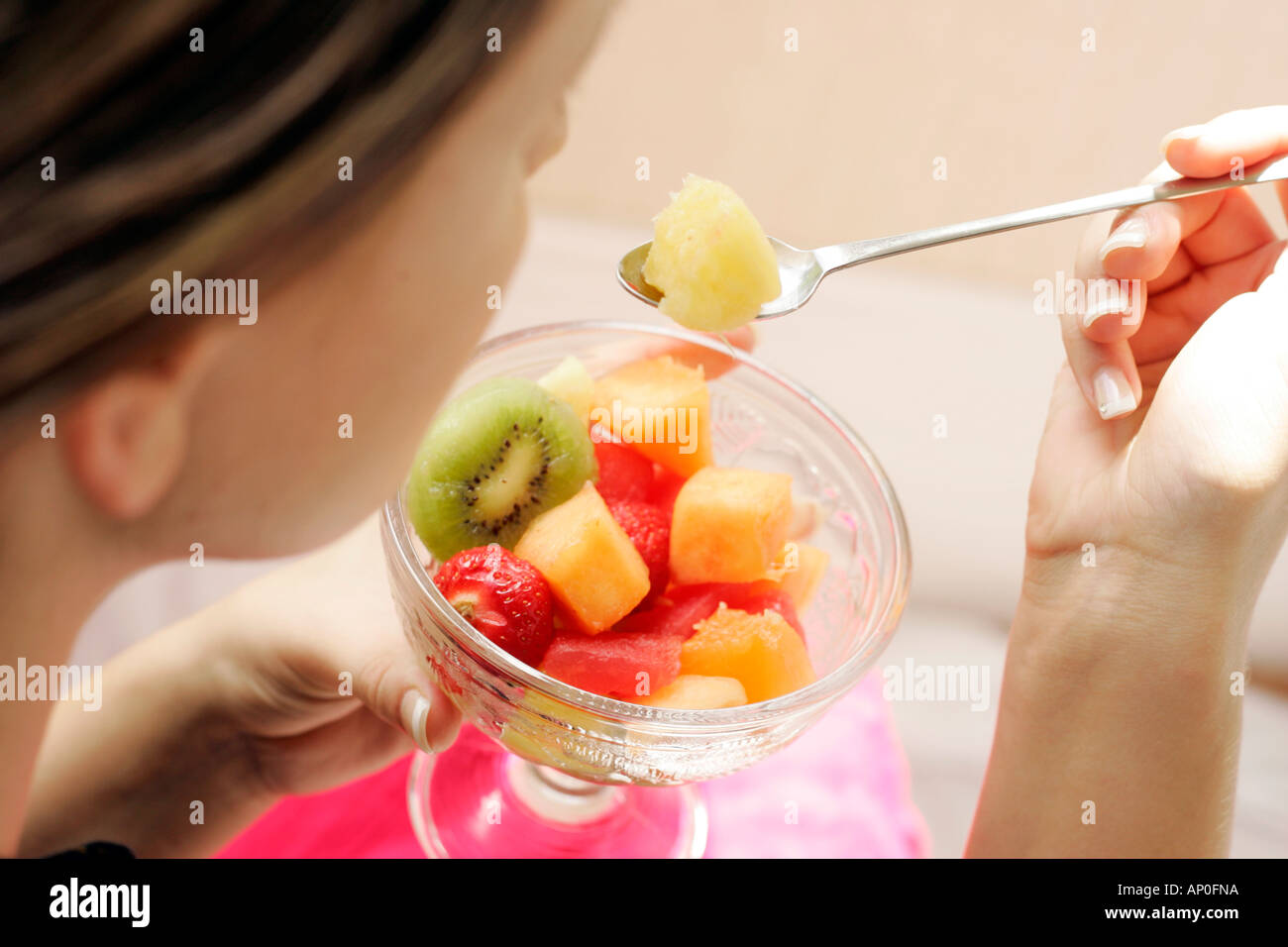 Woman eating fruit salad Stock Photo Alamy