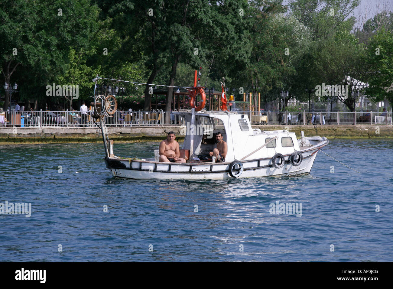two men enjoying their freetime on their little fishing boat istanbul turkey Stock Photo