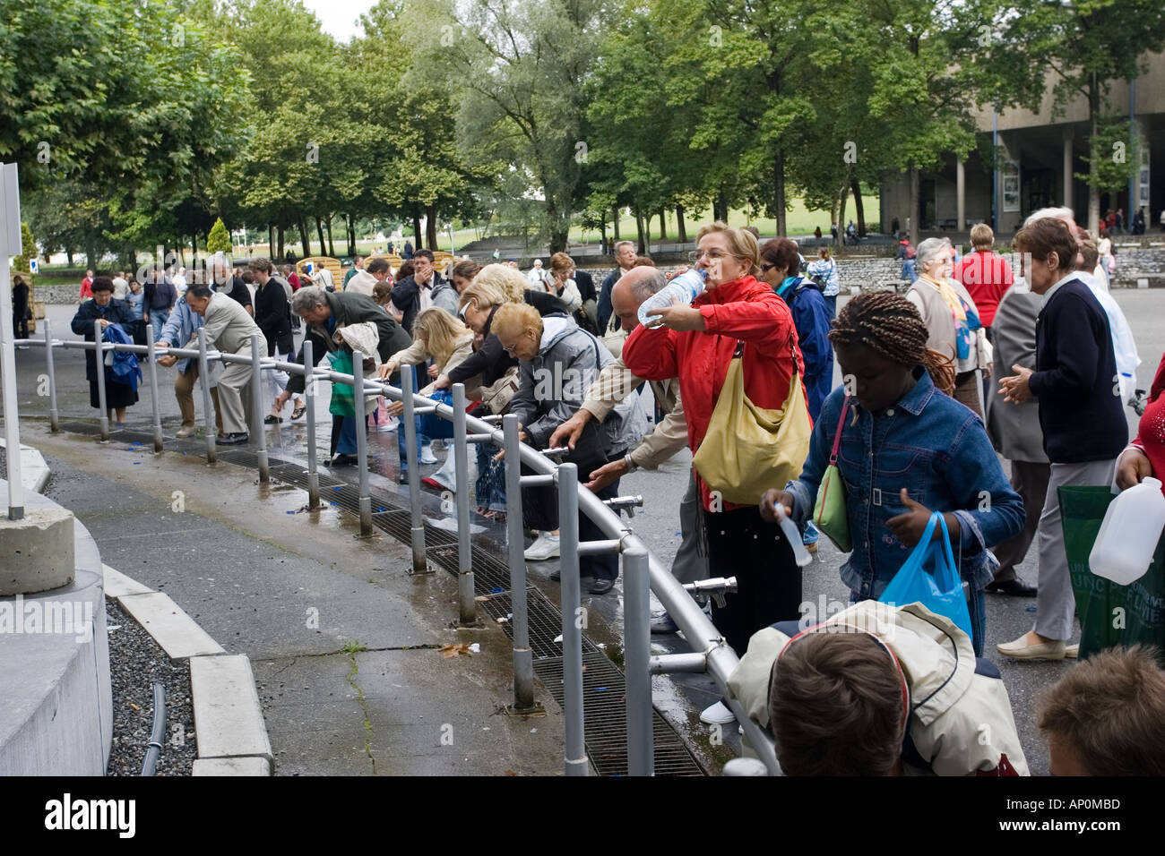 Pilgrims taking holy water next to the Grotto Lourdes France Stock