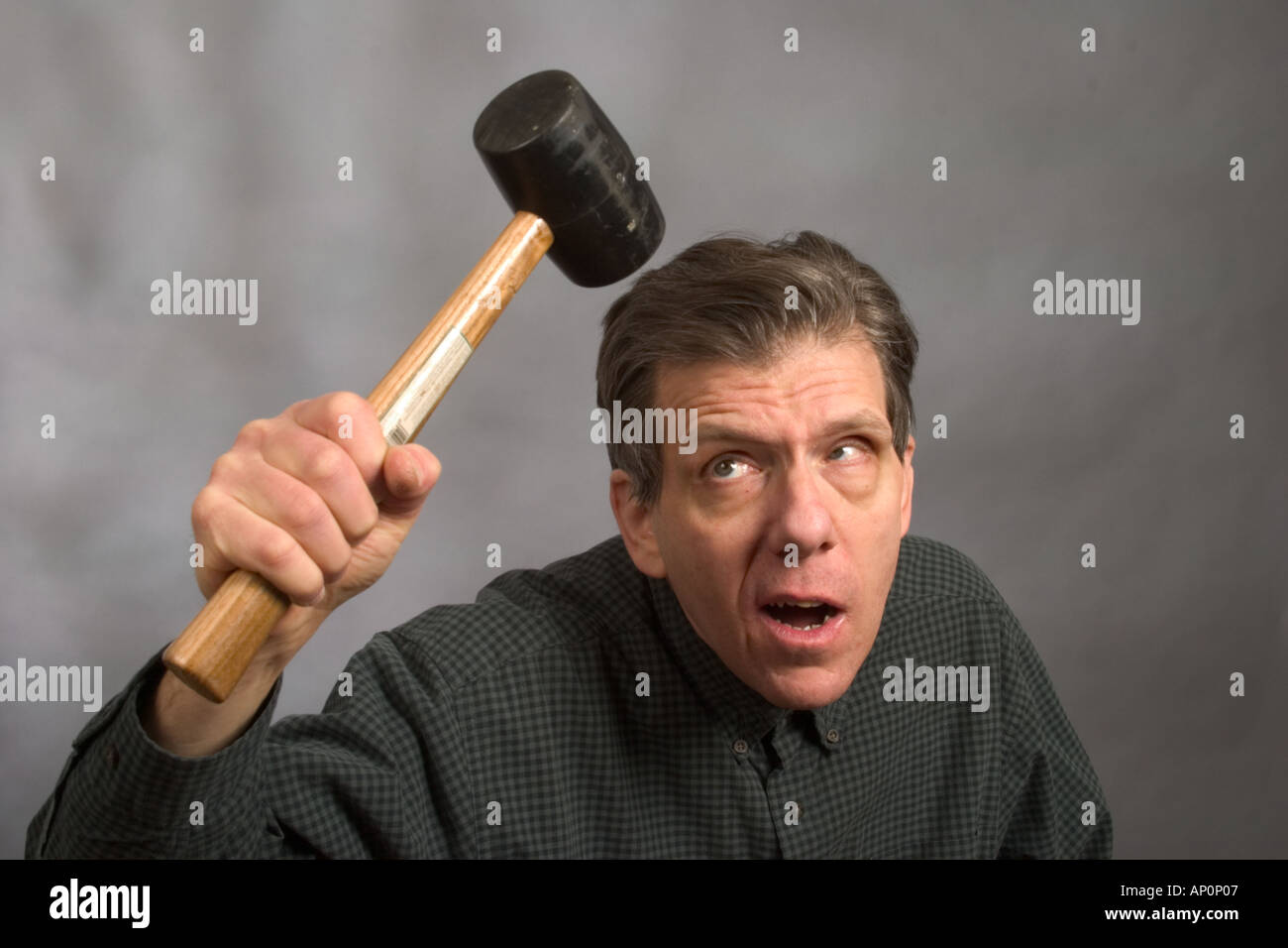 Man about to hit himself on the head with a hard rubber mallet Model