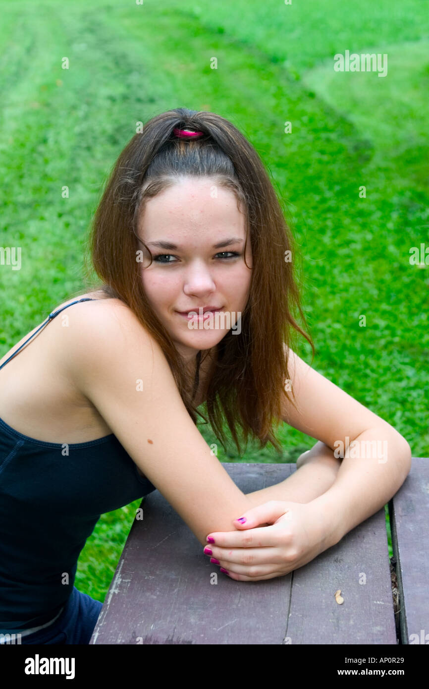 Teen girl sitting at a picnic table Model Released Stock Photo Alamy