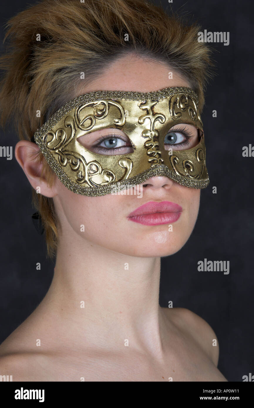 Portrait of a Young Woman Wearing a Gold Carnival Mask Stock Photo