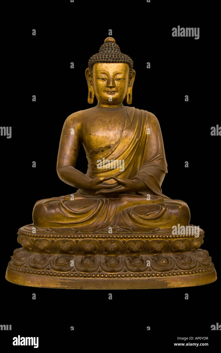Guilded gilt bronze seated hand clasped gesture meditation dhyana mudra short curly hair drawn up topknot gold serene tranquil u Stock Photo