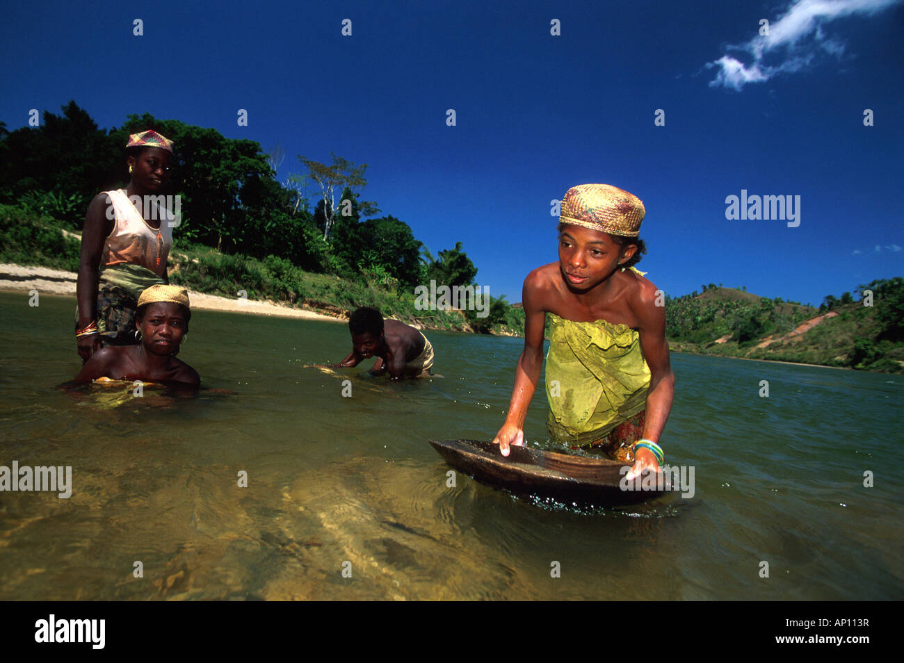 Women panning for gold, Washing gold out of a river, Namarona River, East Madagascar, Africa Stock Photo