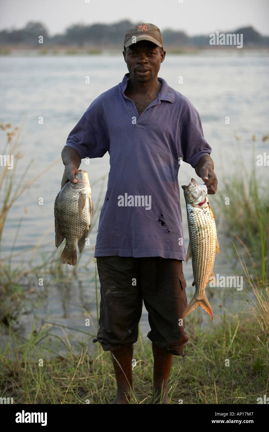 Fisherman on the Zambezi river with a bream and tigerfish Stock Photo
