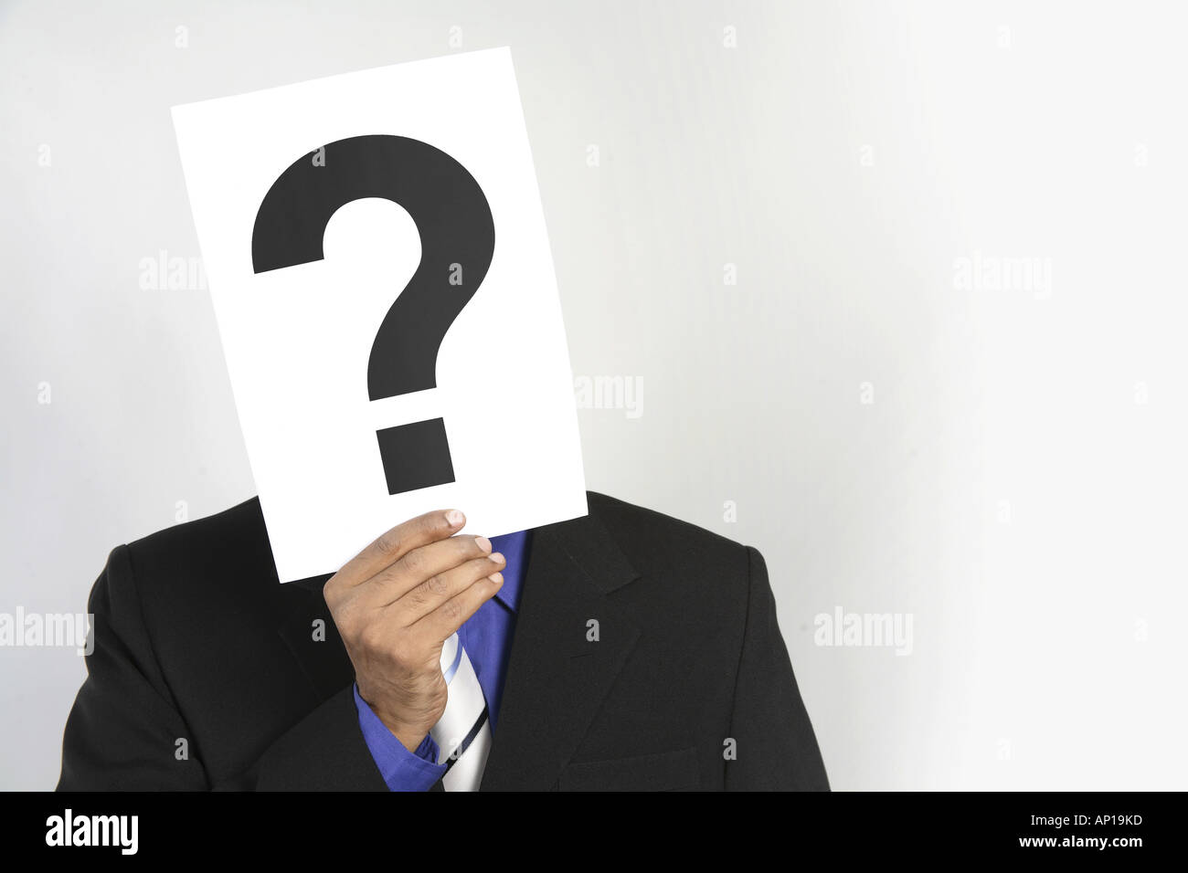 ANG200128 Executive holding paper with the question mark in front of his face wearing black suit Model release No 687M Stock Photo