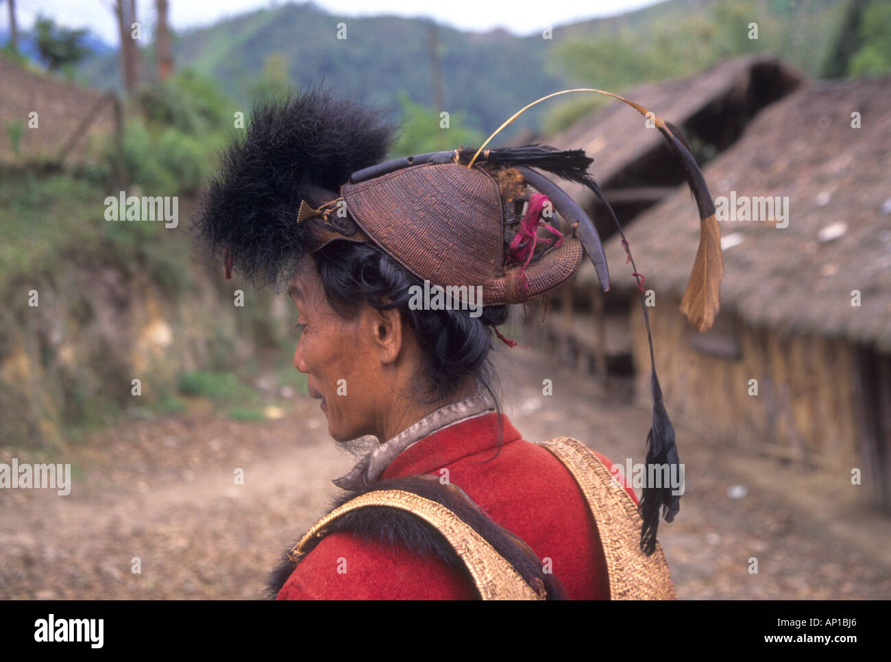 Formerly headhunters Hill Miri tribesmen wear traditional red jackets and animal fur hat and carry swords in scabbards Stock Photo